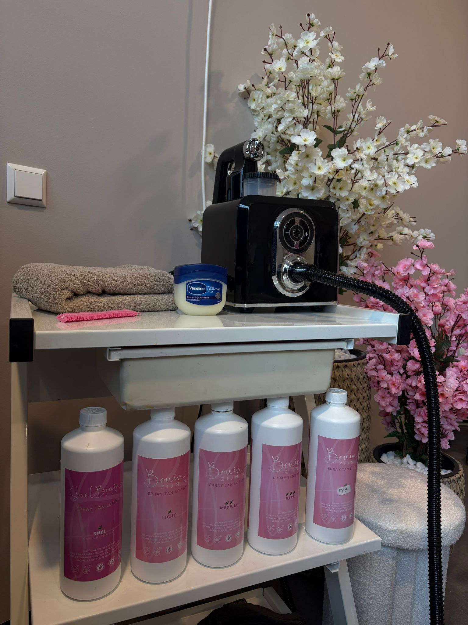 Het spraytanapparaat met de flessen tanninglotion en bloesemtakken